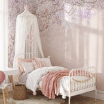 Sakura Nursery Kid Wallpaper Mural installed in a child's bedroom, showcasing the elegant cherry blossom design on a pastel pink wall, complemented by a white canopy bed with pink and white bedding, and delicate decorative elements.