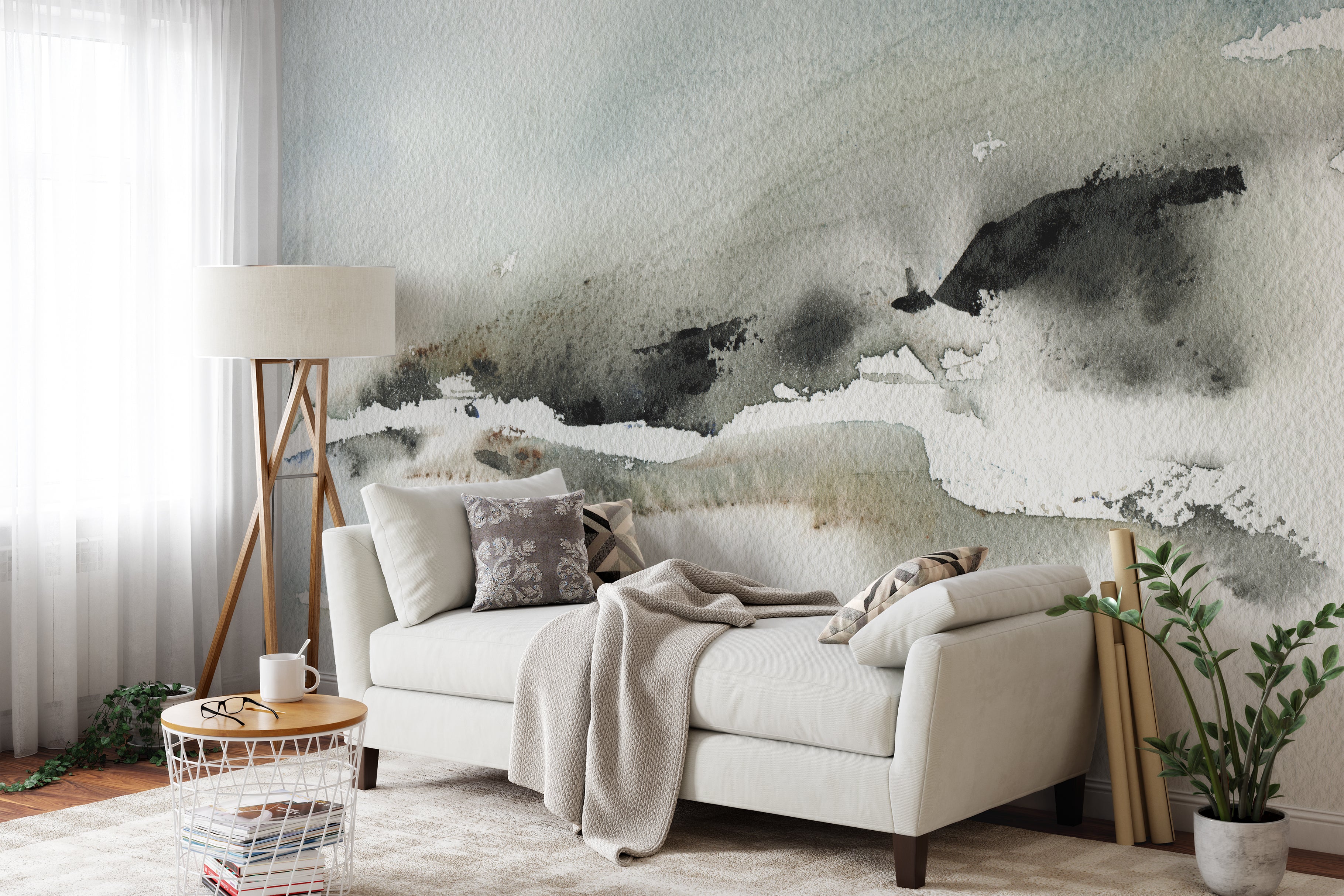 A spacious living room featuring the expansive "Atmospheric Abstraction" wall mural behind a plush beige sofa. The gentle, sweeping brush strokes of the mural in grey and white provide a serene backdrop, complemented by natural wood accents and soft textiles, creating a cozy and inviting environment.