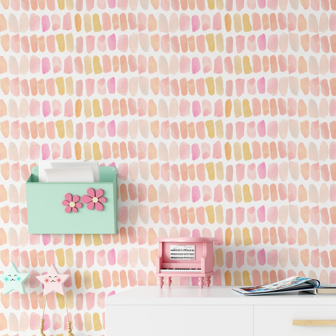 A vibrant and colorful interior scene featuring a wall covered in a hand-painted wallpaper with an array of pastel pink, peach, and yellow dashes. The scene includes a pink toy piano, a green mail organizer with pink flower decorations, and various children's toys, enhancing the playful and creative atmosphere of the room.
