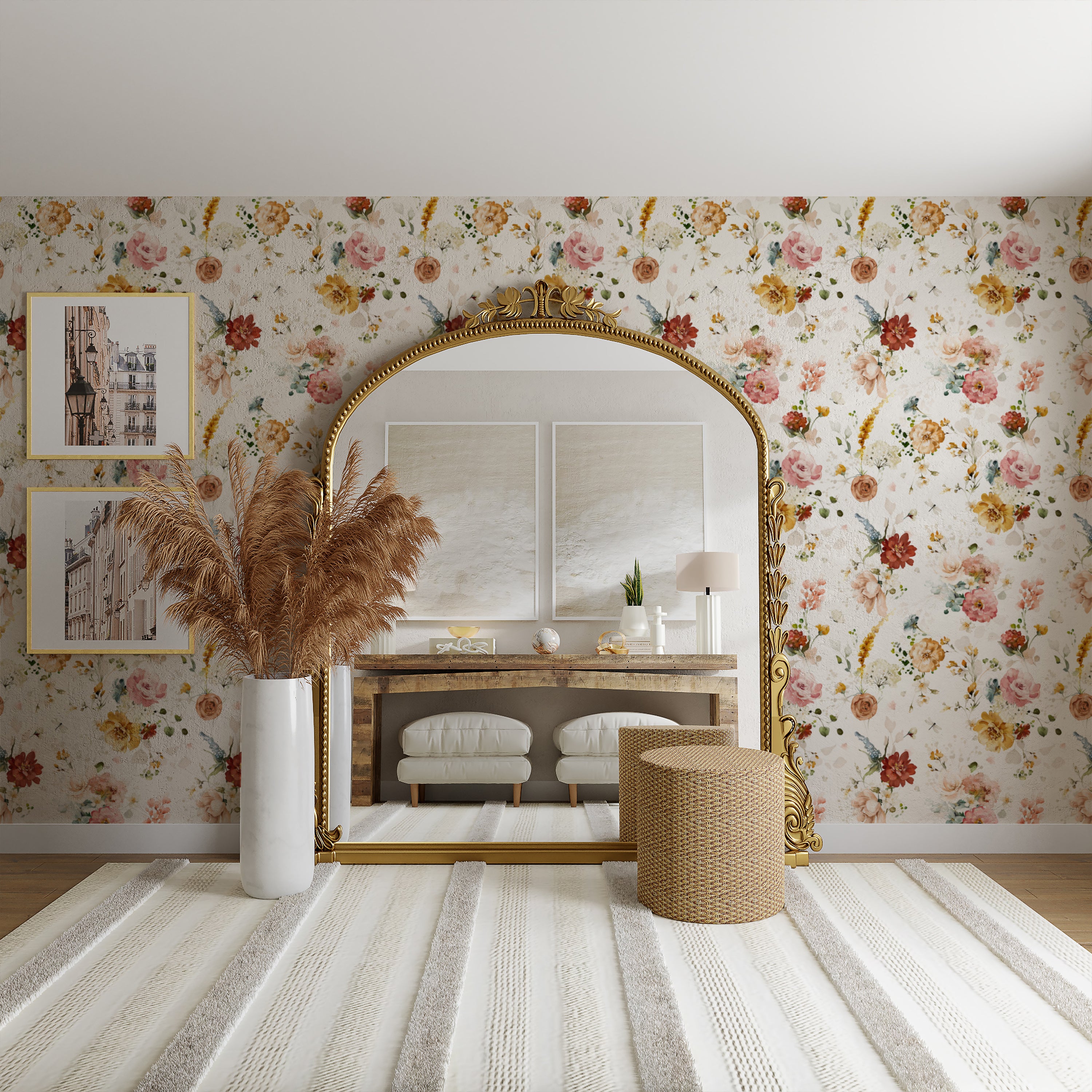 A stylish room interior with a large arched mirror framed in gold. The wall behind is adorned with Garden Flower Wallpaper III featuring a vibrant pattern of assorted colorful flowers on a light background. In front of the mirror is a modern console table with decorative items and a vase of pampas grass.