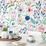 A homey dining area brightened by the Watercolor Floral Wallpaper IV, featuring medium-sized watercolor flowers that bring a burst of color and artistic flair to the room