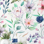 A close-up view of the Watercolor Floral Wallpaper IV in medium, with vibrant watercolor flowers and leaves in pinks, purples, and greens, enhancing a home setting with a tea time arrangement.