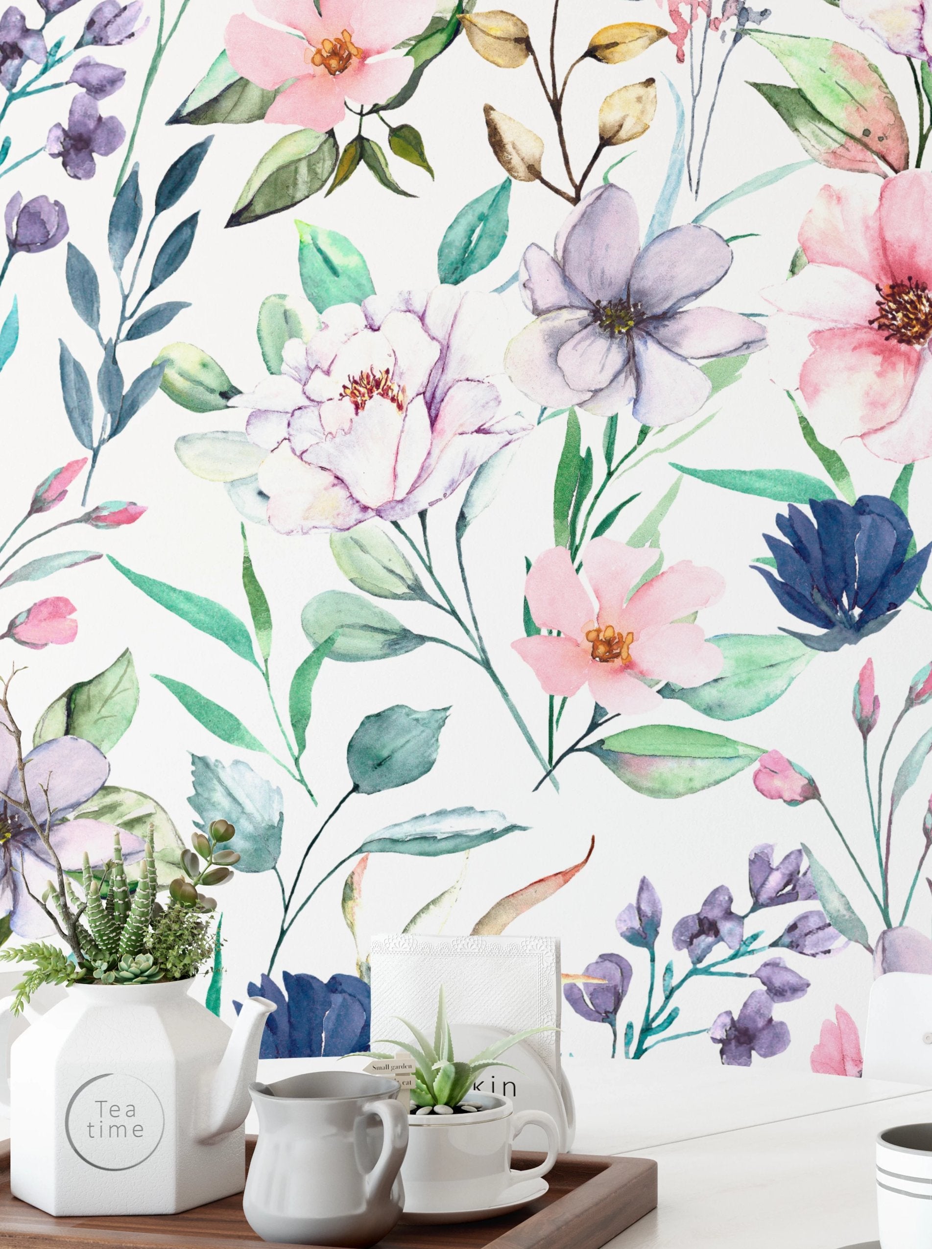 A close-up view of the Watercolor Floral Wallpaper IV in medium, with vibrant watercolor flowers and leaves in pinks, purples, and greens, enhancing a home setting with a tea time arrangement.
