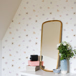 Pressed Flowers II Wallpaper displayed in a room with a decorative mirror and a white table, showcasing the delicate floral pattern with soft pastel colors.