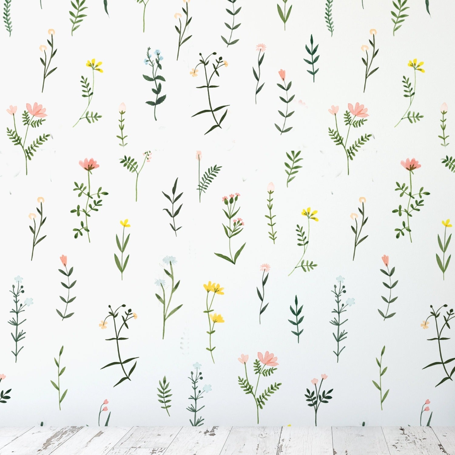 A wall covered with 'Floral Wallpaper - XII', showcasing an array of delicate flowers and greenery. The pattern is evenly spaced, creating a sense of a wildflower meadow brought indoors. The colors are gentle, with pastel pinks, yellows, and greens that add a playful yet elegant touch to the room.