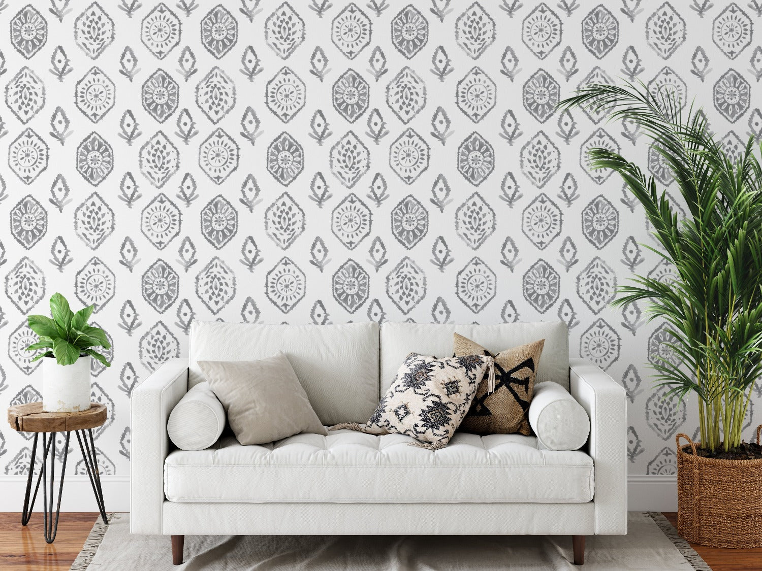 A stylish living room with one wall adorned with the Moroccan Tile Wallpaper IX, complementing the contemporary decor including a white couch with patterned cushions, a tall indoor plant, and elegant drapery.