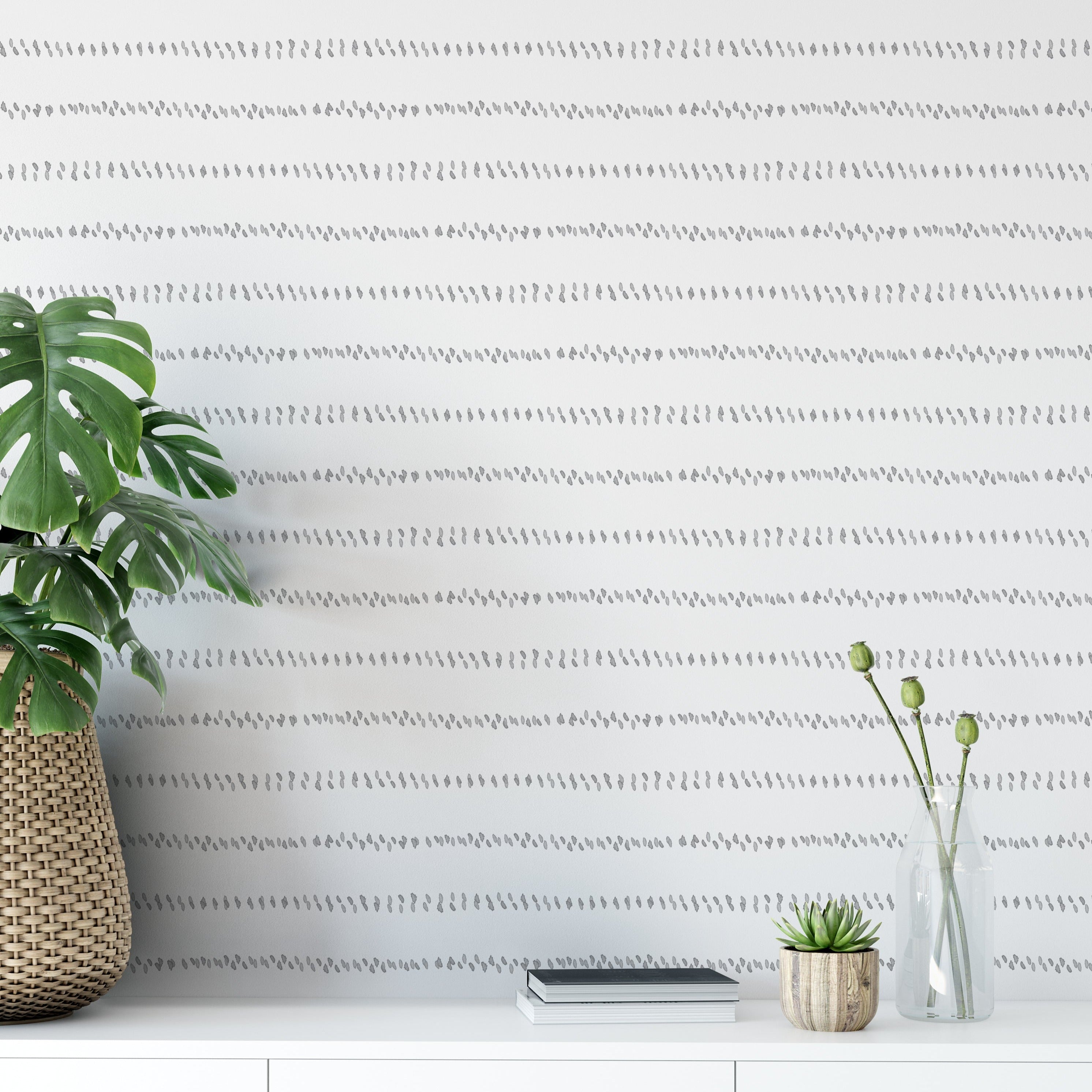 A modern room featuring the Watercolour Minimal Wallpaper II, with subtle gray watercolor dashes forming horizontal lines on a white wall, providing a serene and sophisticated backdrop that complements the contemporary decor.