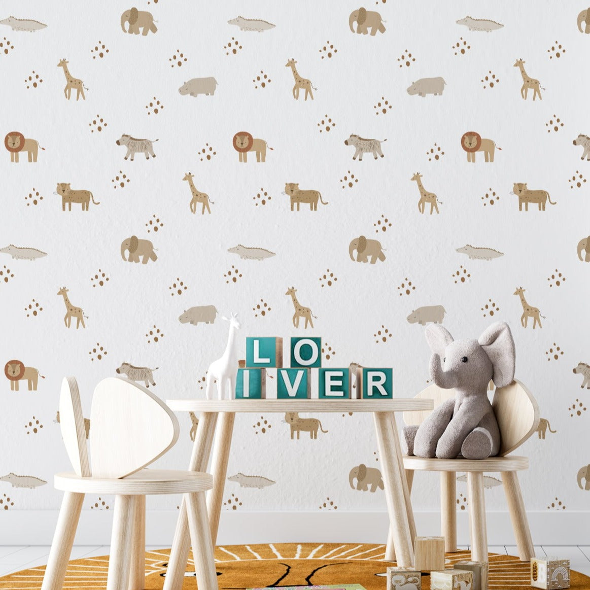 the wallpaper creates a delightful backdrop to a child's study and play area, featuring a wooden table and chairs with a plush elephant toy sitting attentively. The safari theme of the wallpaper adds a sense of adventure and curiosity to the learning environment, enhancing the room with a sense of whimsy and wonder.