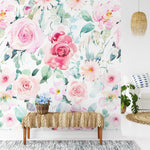 A living room setting with a large section of Pink Floral Wallpaper on the wall. The vibrant floral design includes various shades of pink roses and green leaves, creating a cheerful and lively atmosphere.