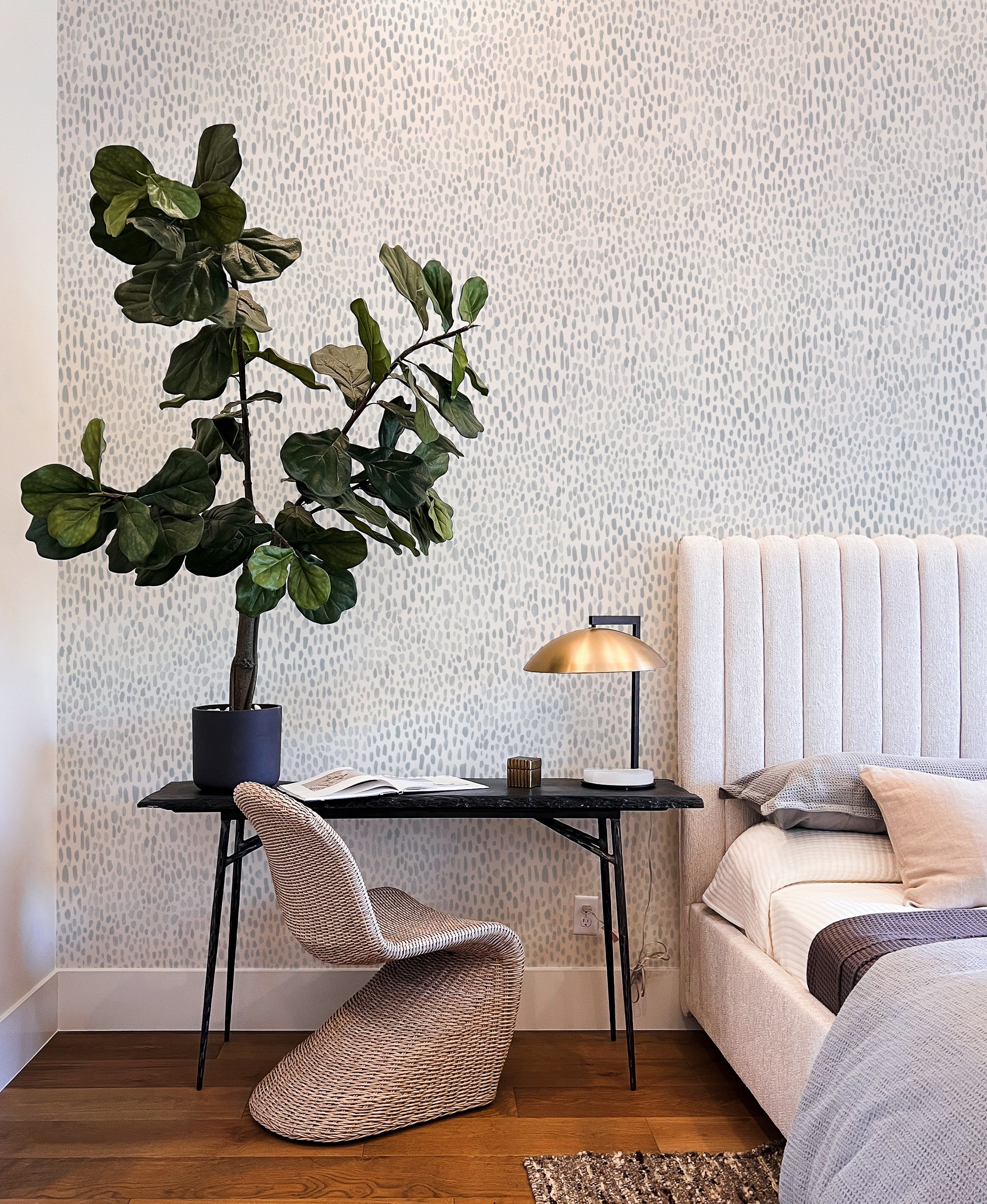 Big Boho Hand Painted Dots Wallpaper' adorns a chic room's wall, providing a stylish backdrop to a cozy reading nook with a plush armchair, elegant lamp, and a lush potted plant