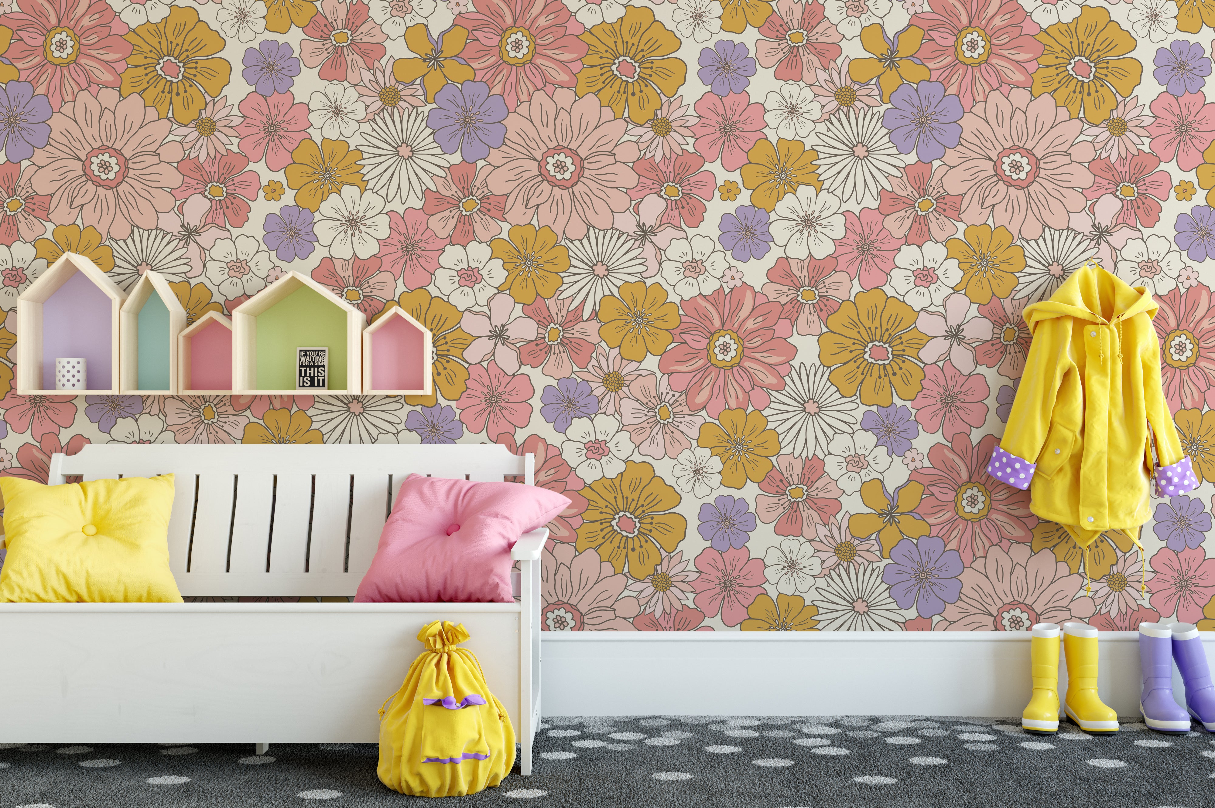 A playful children's room decorated with Retro Groovy Flower Wallpaper, which boasts a colorful floral pattern. The room features a white bed, colorful house-shaped shelves, and a bright interior that complements the lively wallpaper