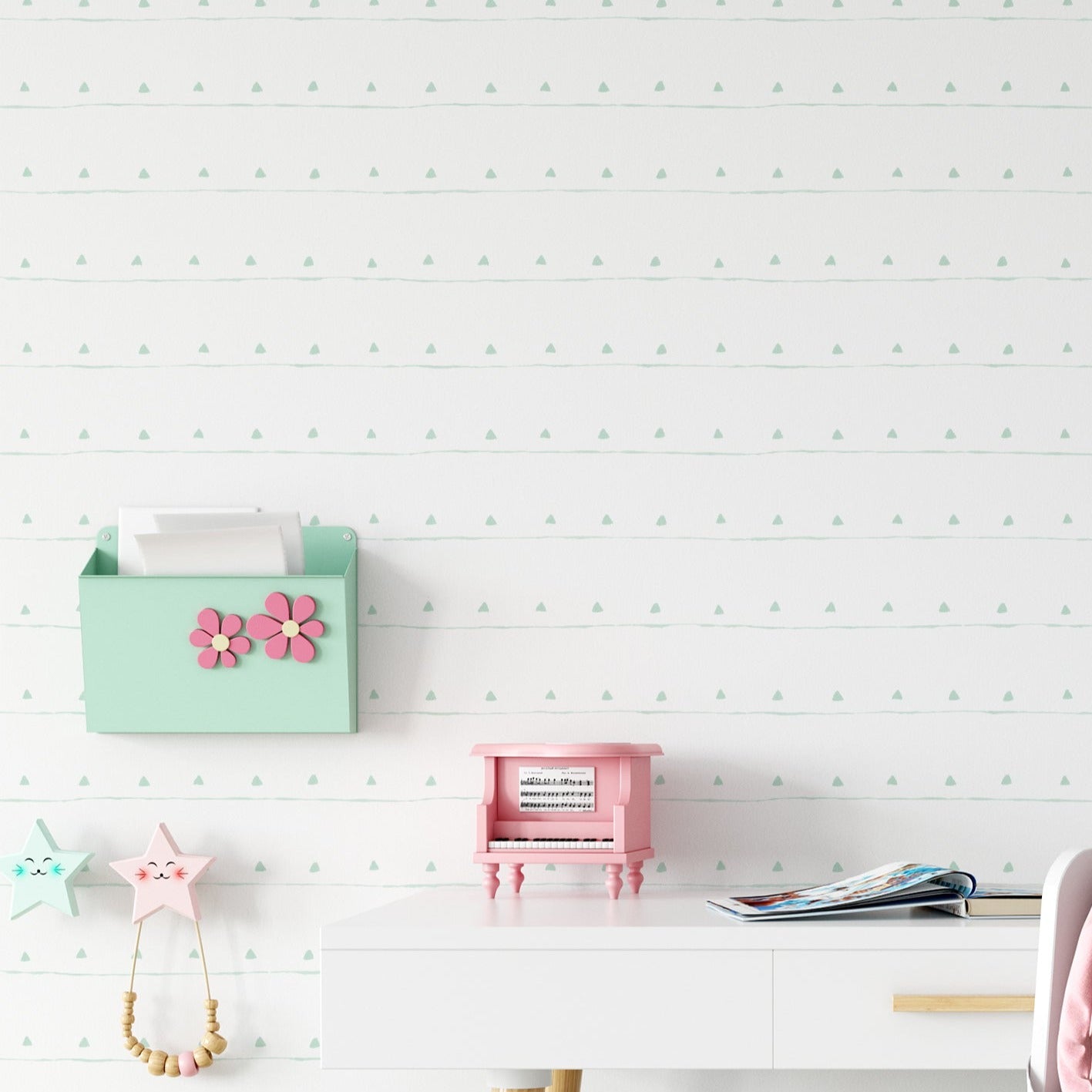 A stylish children's workspace set against the Kids Boho Wallpaper - 132 with a light green backdrop and delicate white triangles, decorated with a modern desk, toys, and vibrant accessories