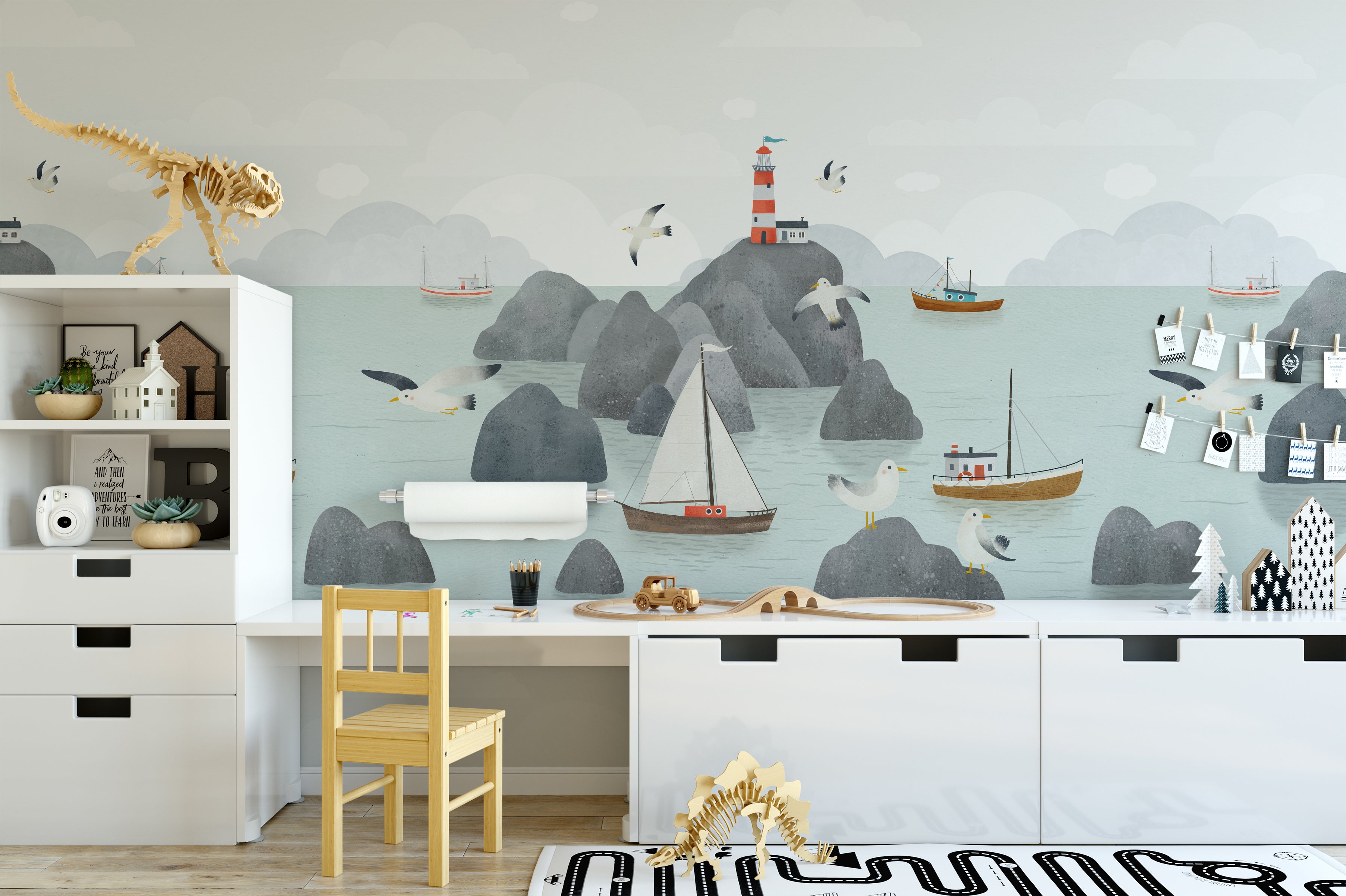 a detailed look at the wallpaper's design, highlighting the gentle watercolor style of the sailboats, the quaint lighthouse, and the playful seagulls. The illustration is set against a peaceful background of rounded mountains and a soft sky, creating a sense of calm and imagination for a child's room.