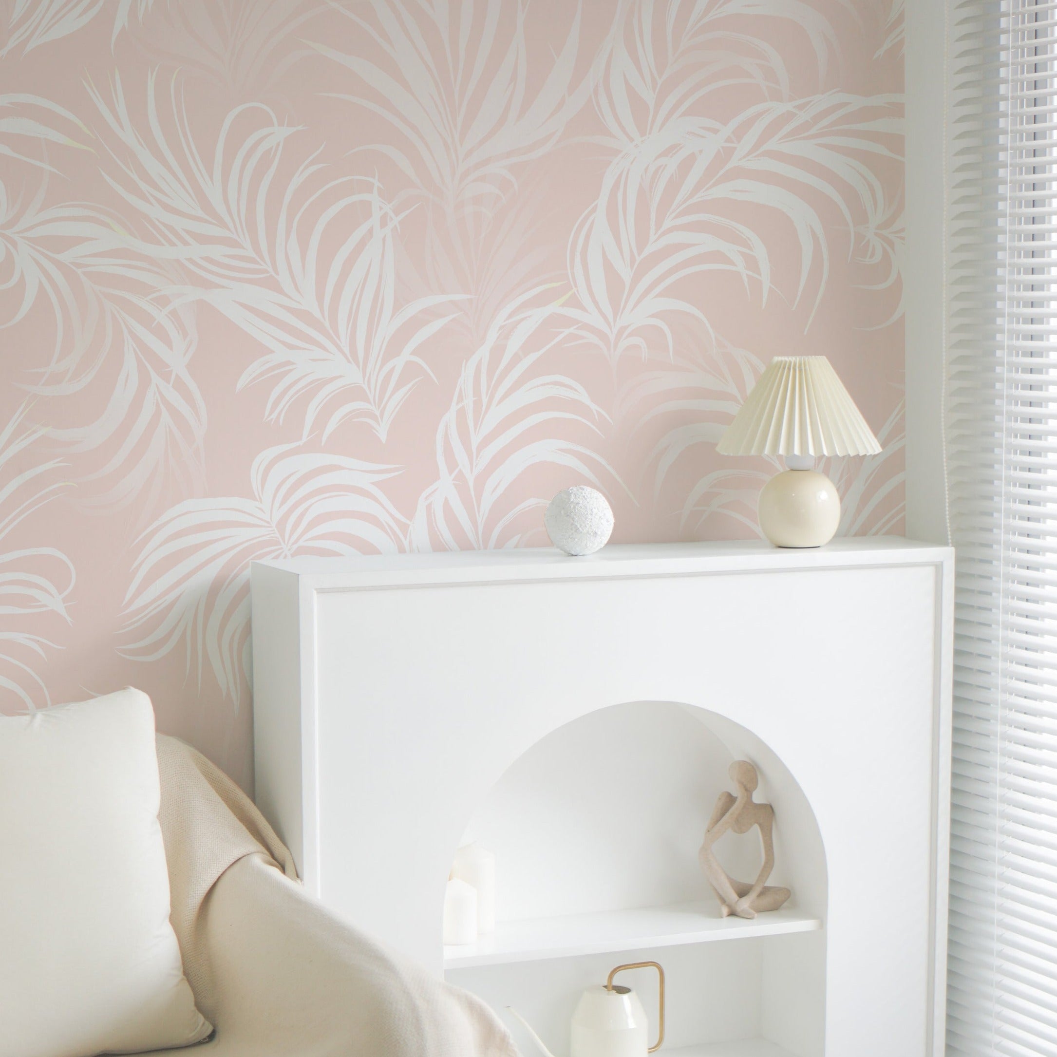 A serene bedroom setting adorned with "Tropical Champagne Wallpaper," which frames a white sideboard and minimalist decor. The wallpaper's soft hues and tropical designs create a calm, relaxing environment that is both stylish and comforting.
