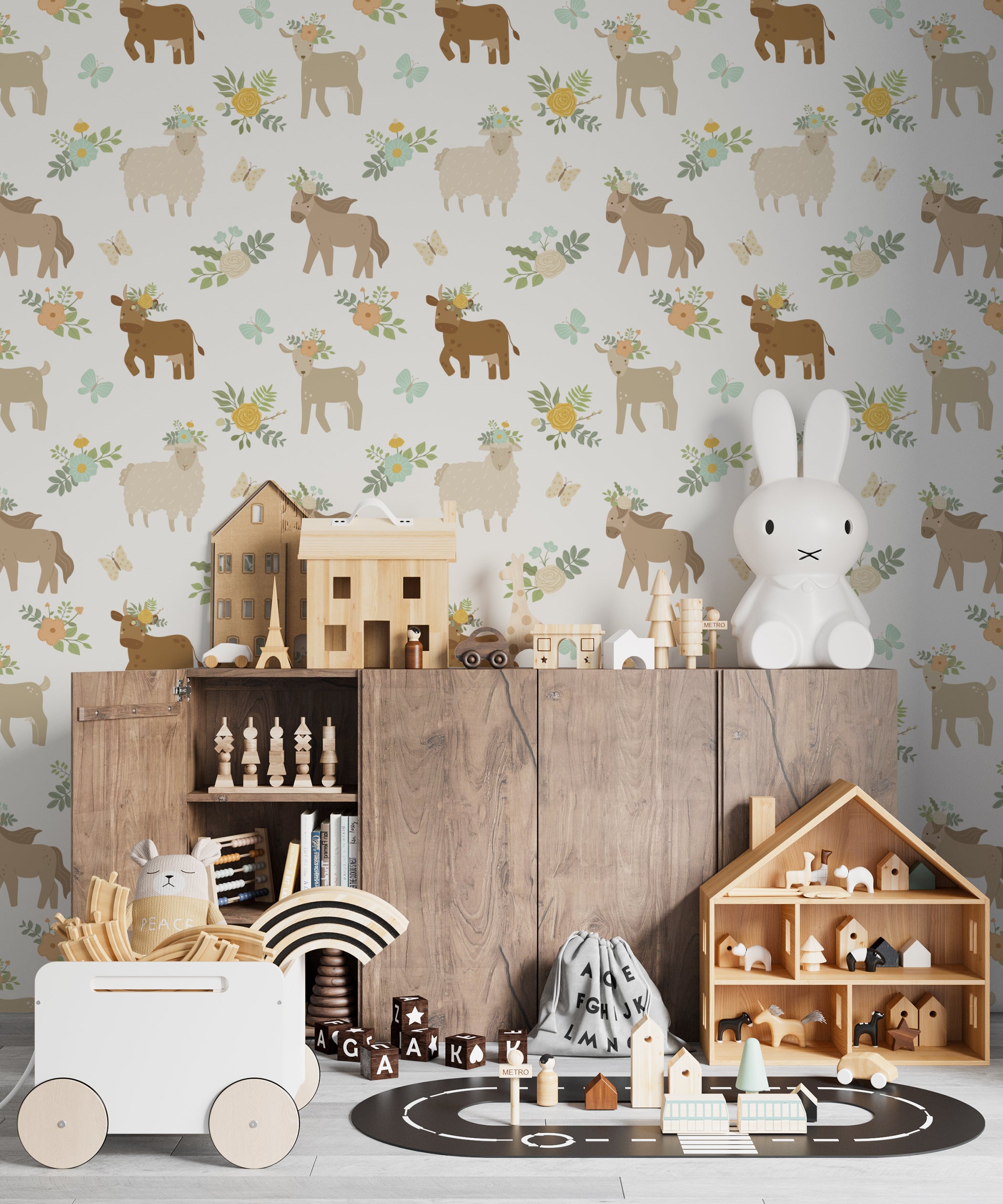 A child's playroom decorated with 'Spring Farm Animals Wallpaper' displaying soft-colored farm animals with floral decorations amidst greenery and butterflies, complementing the natural wood furniture and playful room setting