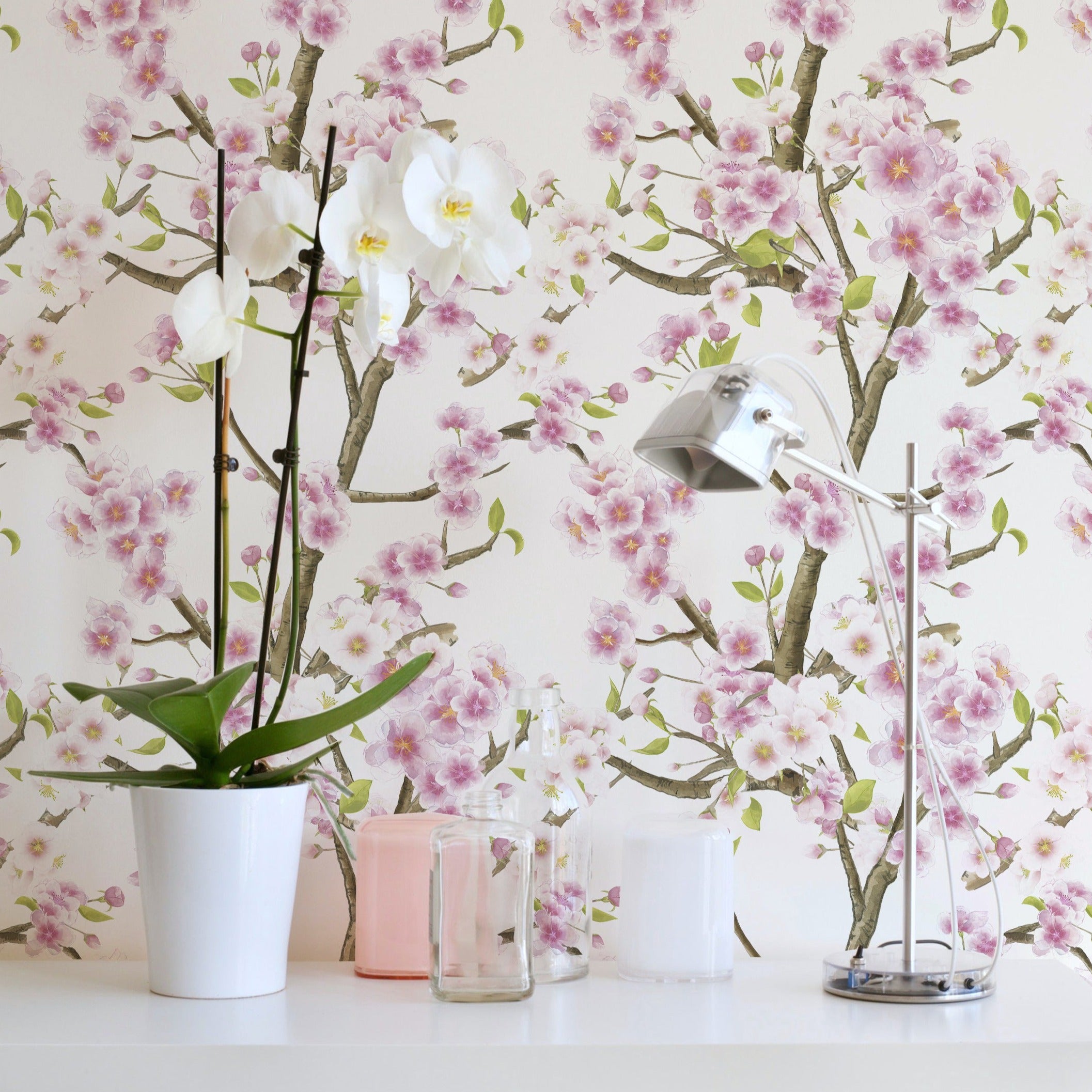 Sakura Blossom Wallpaper enhancing a contemporary bathroom setting, with vibrant pink cherry blossoms on slender branches spread across a white background, paired with modern decor and natural elements for a refreshing interior.