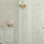 The Gold Leaves Wallpaper graces a classic room with white molding and elegant decor, adding a touch of sophistication with its golden watercolor leaves against the soft background.