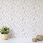 A close-up of the Subtle Botanica Wallpaper showcasing its fine details: leafy branches in a soft taupe color spread across a faux linen texture, offering a gentle and naturalistic design that adds a peaceful ambiance to any space.