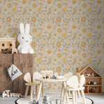A children's playroom with furniture, including a small wooden table and chairs set, in front of a wall covered in 'Retro Flower Wallpaper' featuring a repeating pattern of large, stylized flowers in muted tones of cream, beige, yellow, and green