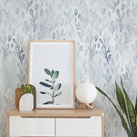 Room setup featuring Floral Foil Wallpaper II on the walls, complemented by minimalistic decor including a framed botanical print and modern furniture. The wallpaper adds a gentle, nature-inspired ambiance to the space.