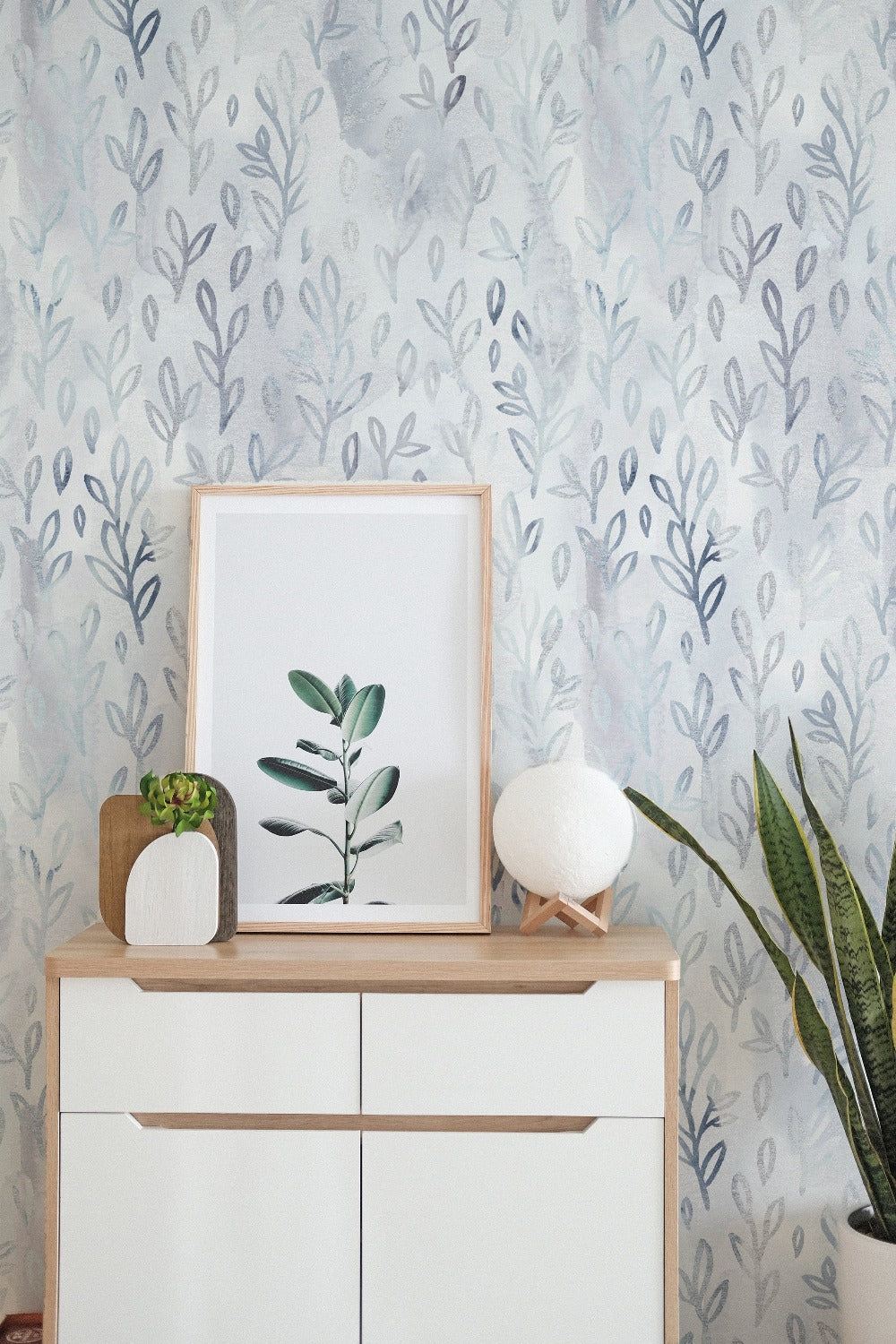 Room setup featuring Floral Foil Wallpaper II on the walls, complemented by minimalistic decor including a framed botanical print and modern furniture. The wallpaper adds a gentle, nature-inspired ambiance to the space.