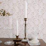 The 'Boho Branches Wallpaper' adds a touch of natural sophistication to a dining area, with tall candles and crystal glassware enhancing the elegance of the setting.