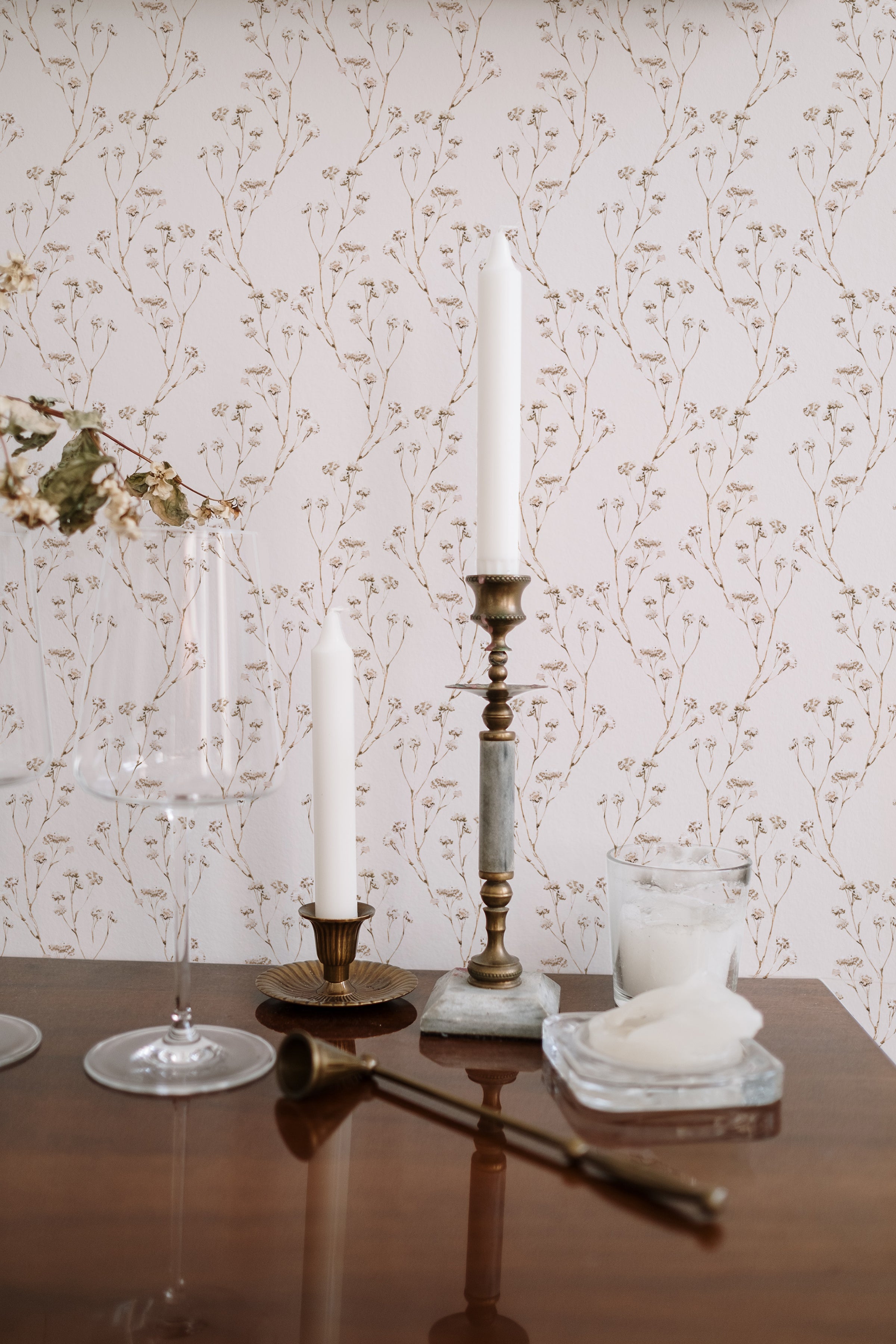 The 'Boho Branches Wallpaper' adds a touch of natural sophistication to a dining area, with tall candles and crystal glassware enhancing the elegance of the setting.