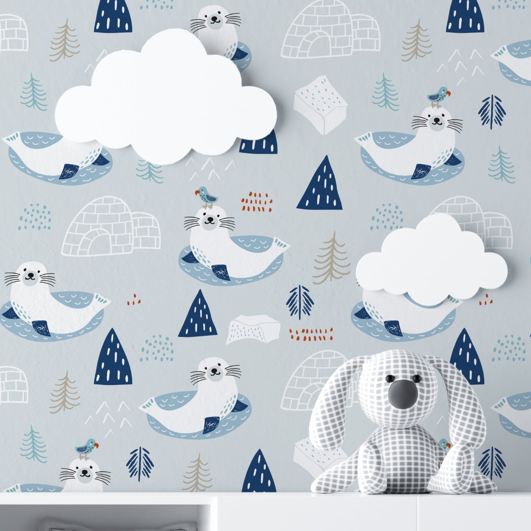 A child's room featuring the "Nordic Seal Wallpaper," where joyful seals lounging on ice floats set a playful and calm backdrop. The room includes white storage units, soft plush toys, and a cozy setting that echoes the wallpaper's serene Arctic theme.