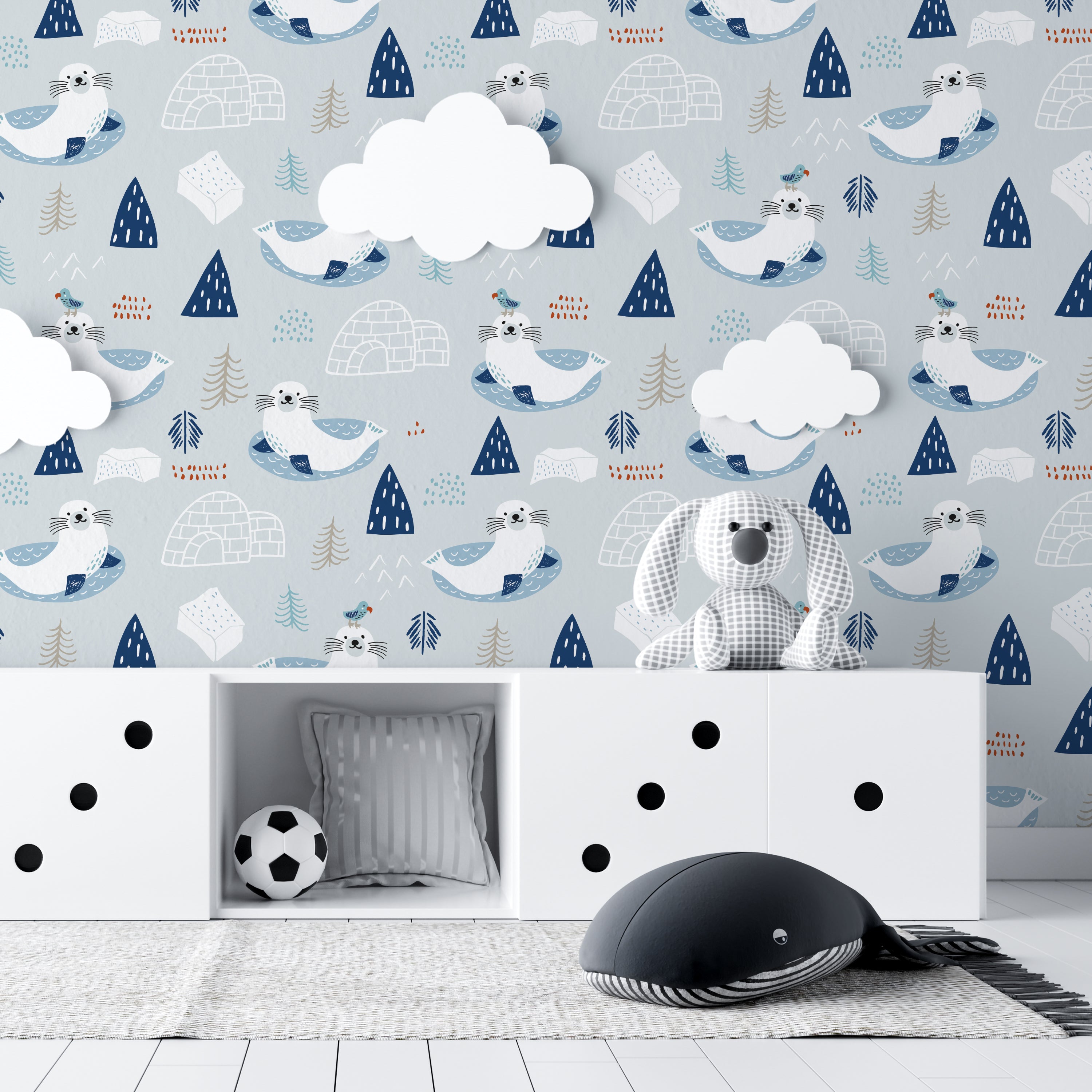 A child's room featuring the "Nordic Seal Wallpaper," where joyful seals lounging on ice floats set a playful and calm backdrop. The room includes white storage units, soft plush toys, and a cozy setting that echoes the wallpaper's serene Arctic theme.