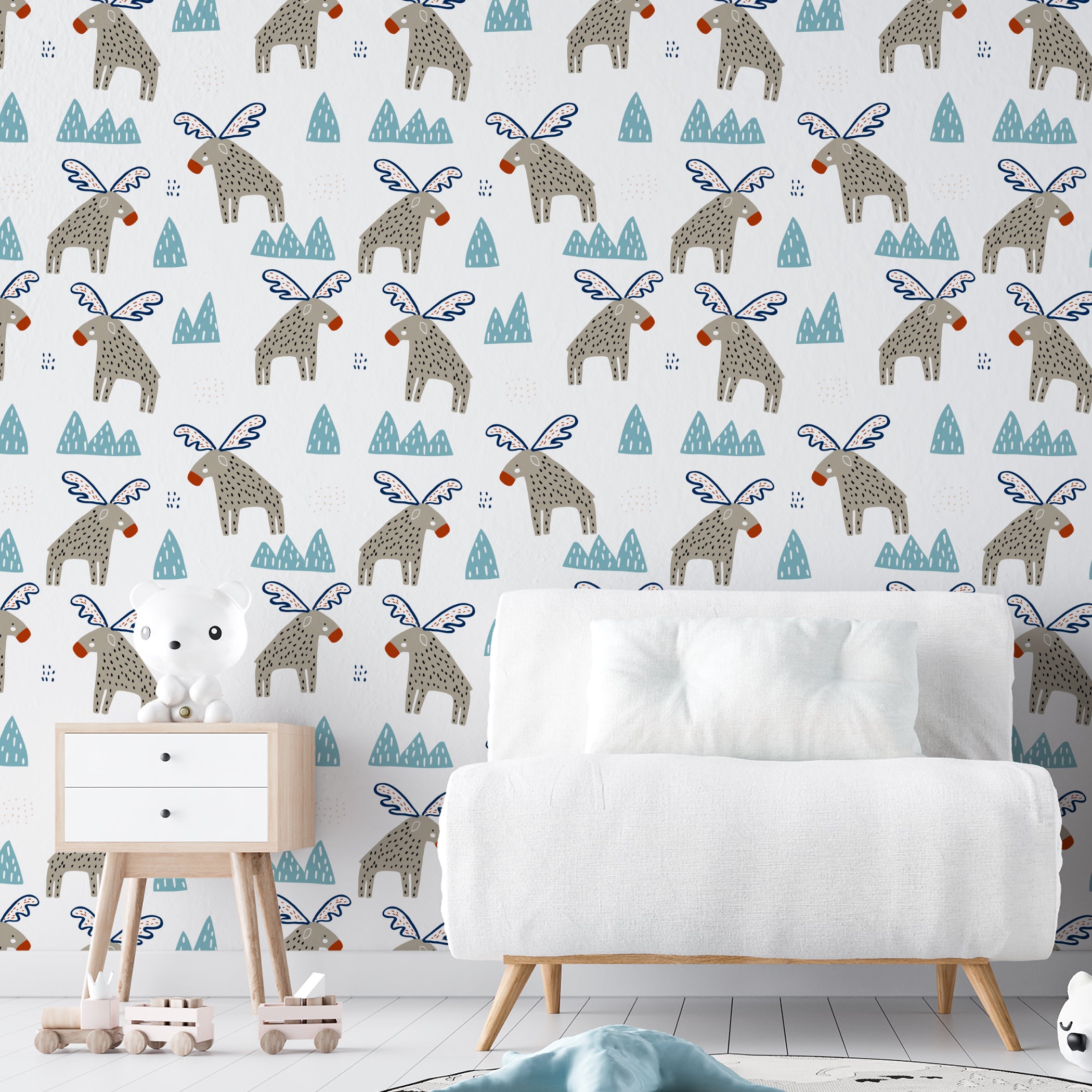 A child's room decorated with "Nordic Moose Wallpaper II" showcasing playful winged moose in a fantastical setting. The room includes modern children’s furniture such as a small white couch, a polar bear toy, and a simplistic yet stylish decor that complements the lively wallpaper.