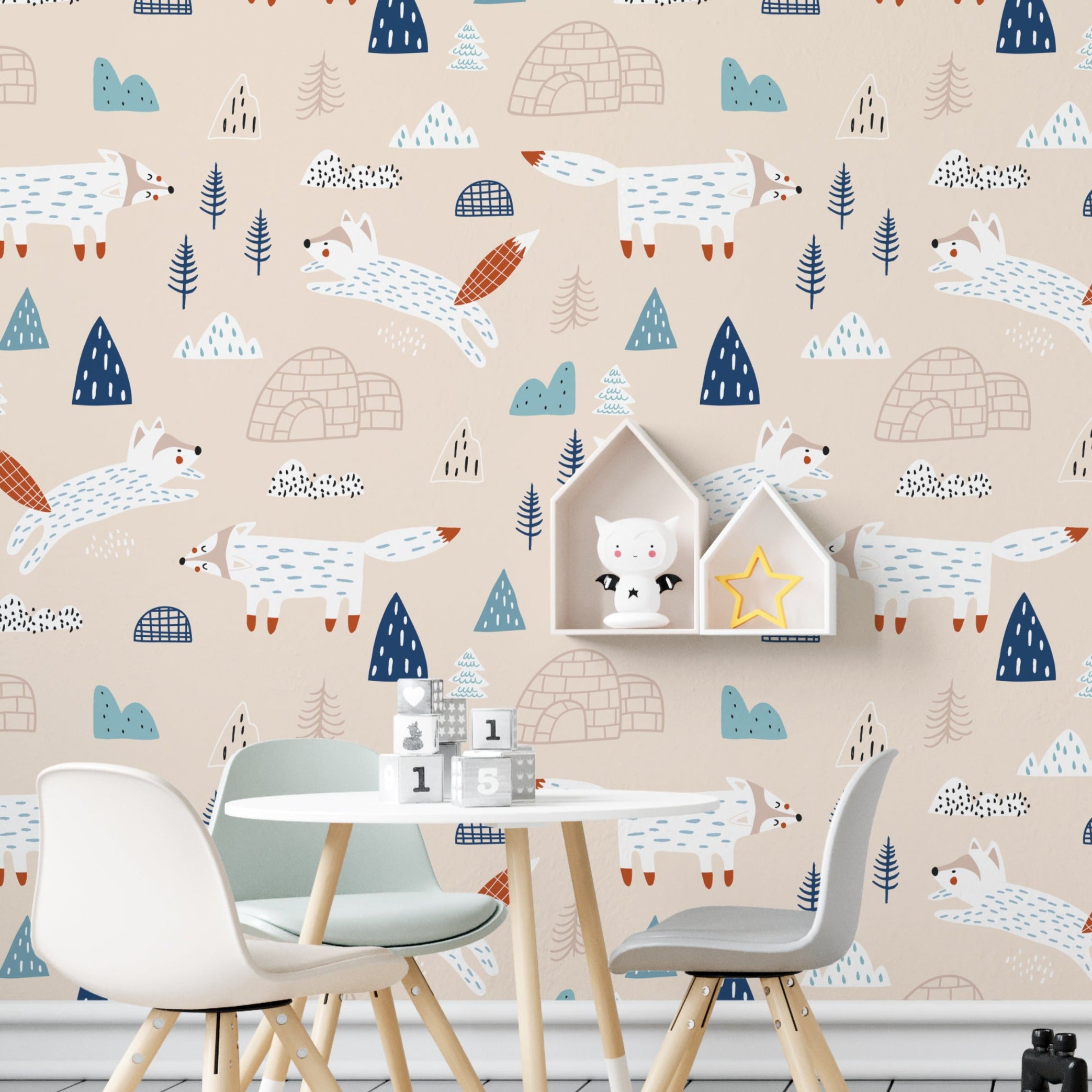A child's study area with walls covered in "Nordic Fox Wallpaper" showing a charming scene of blue and white foxes, small igloos, and stylized trees on a beige backdrop. The setting includes a small table and chairs, and a white bed, enhancing the room's whimsical and educational atmosphere.