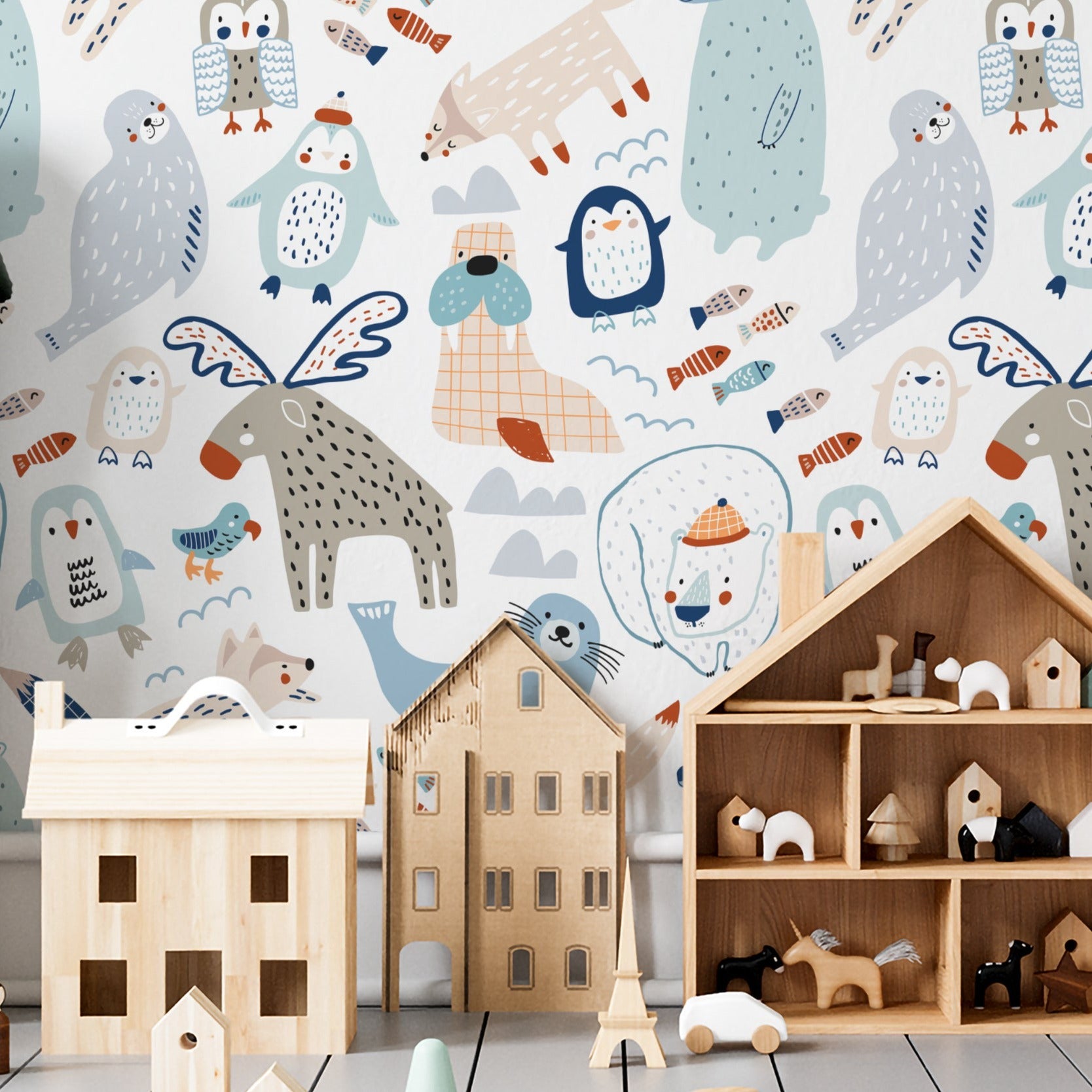 A nursery room decorated with "Nordic Moose Wallpaper" showing a vibrant and playful animal pattern. The room includes a white bookshelf filled with children's books and toys, a wooden playhouse, and a toy car track, all complemented by the cheerful wall design.