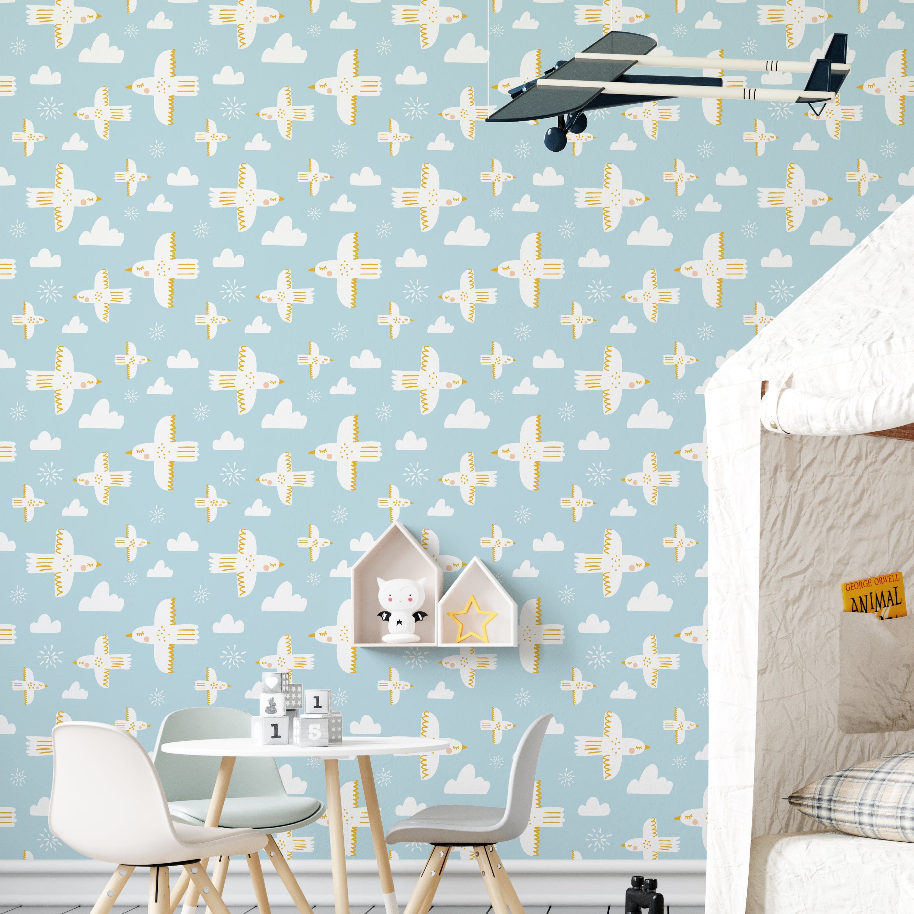 A children's playroom wall covered with Spring Sky Wallpaper showcasing playful white birds flying amongst clouds and stars on a serene blue background, enhancing the room's cheerful and airy feel