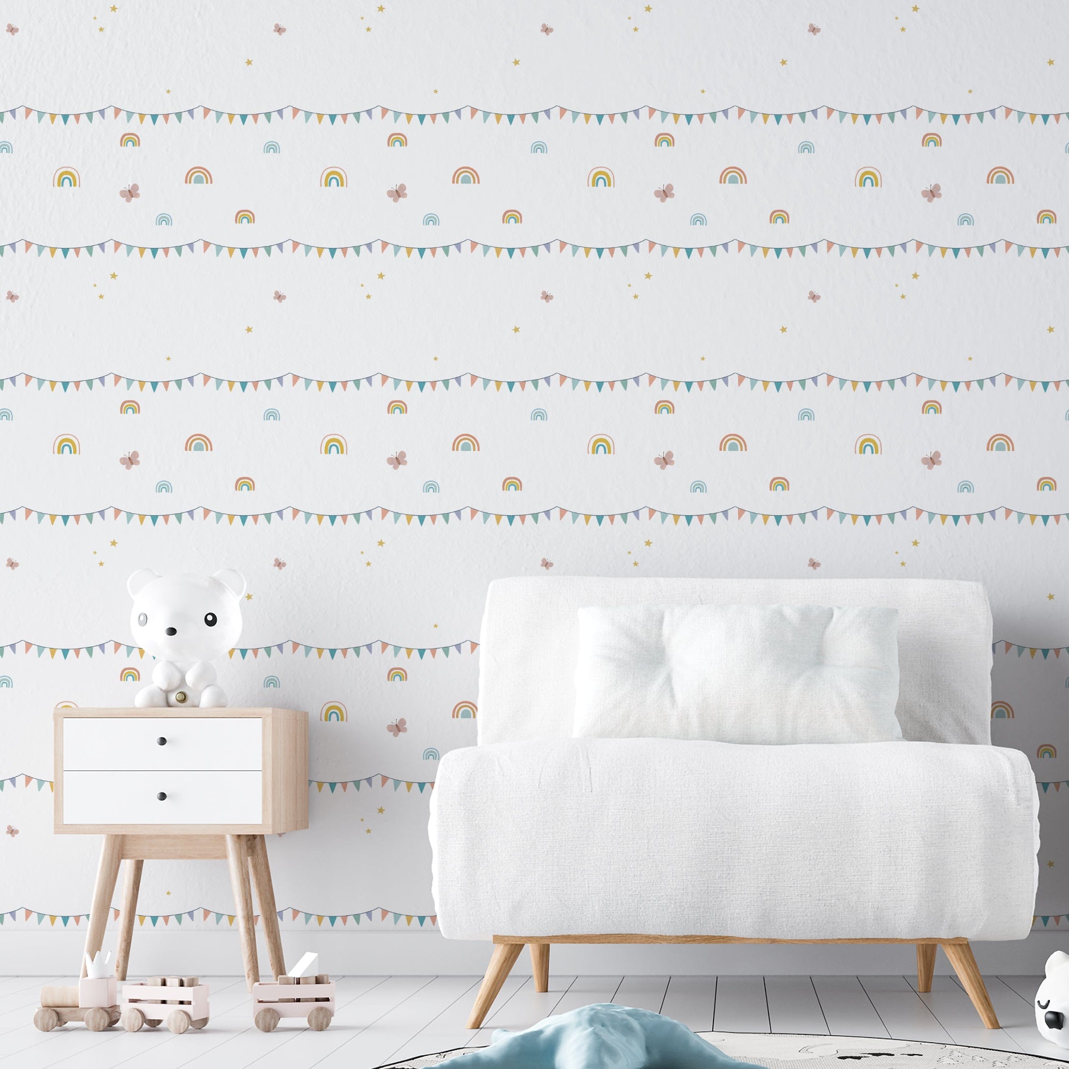 A nursery room wall decorated with the Rainbow Adventure wallpaper showcasing pastel rainbows, bunting flags, and twinkling stars, providing a joyful and stimulating environment for a child