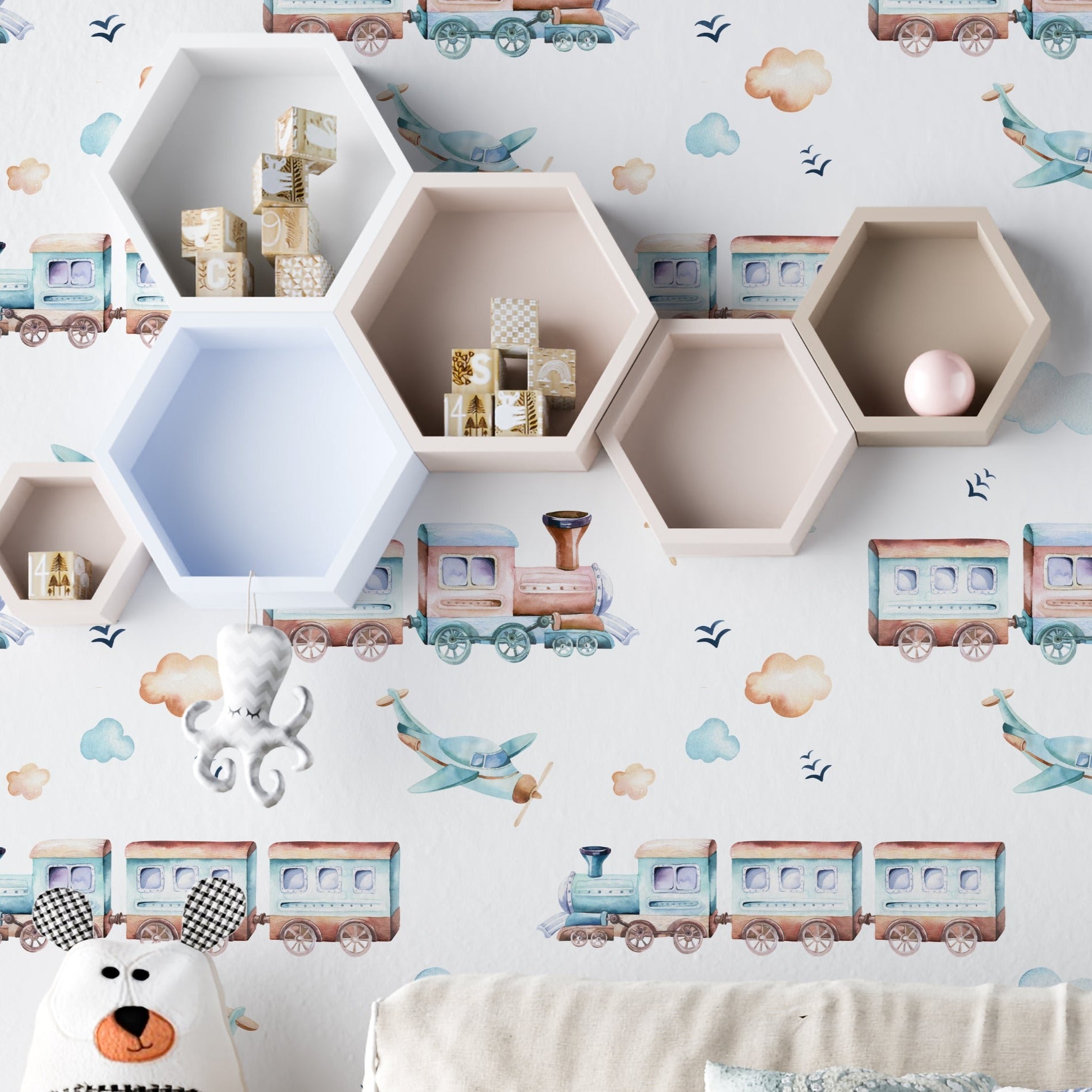 A playful children's room featuring 'Trains and Planes Kids Wallpaper III.' This charming wallpaper includes vintage-style trains and propeller planes interspersed with fluffy clouds and tiny birds, creating an adventurous sky scene. The room is enhanced with hexagonal shelves and whimsical decor, making it a perfect haven for young explorers