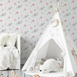 A child’s playroom decorated with the 'Fairy and Flowers II' wallpaper, displaying a subtle and charming pattern of pink butterflies, teal floral wreaths, and tiny hearts. The soft colors and gentle designs complement the room’s white furnishings and playful decor, creating a serene and inviting space