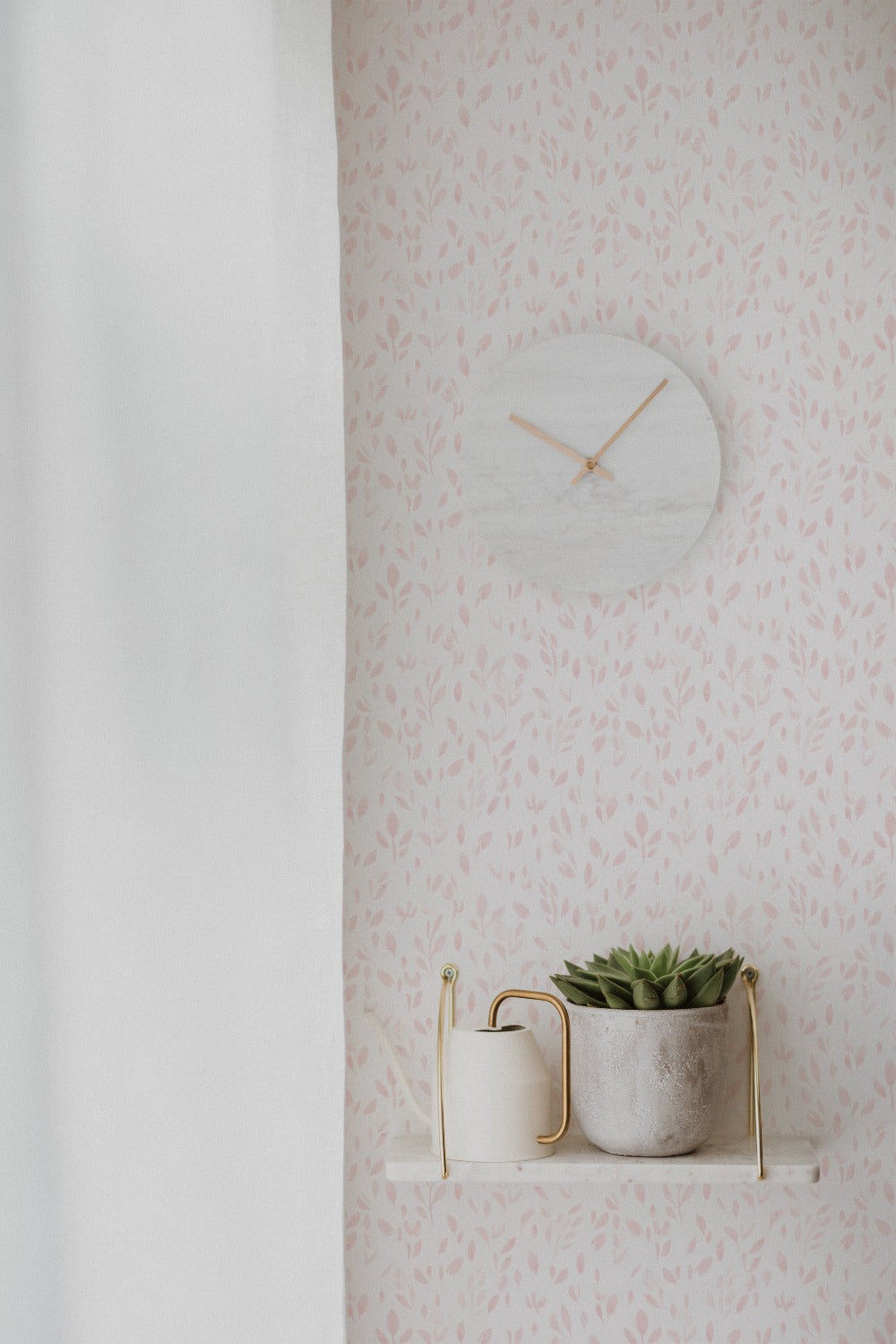 Minimalist style room showcasing the Subtle Botanica Wallpaper III with delicate pink foliage patterns, complemented by a sleek white clock and a potted succulent on a floating shelf