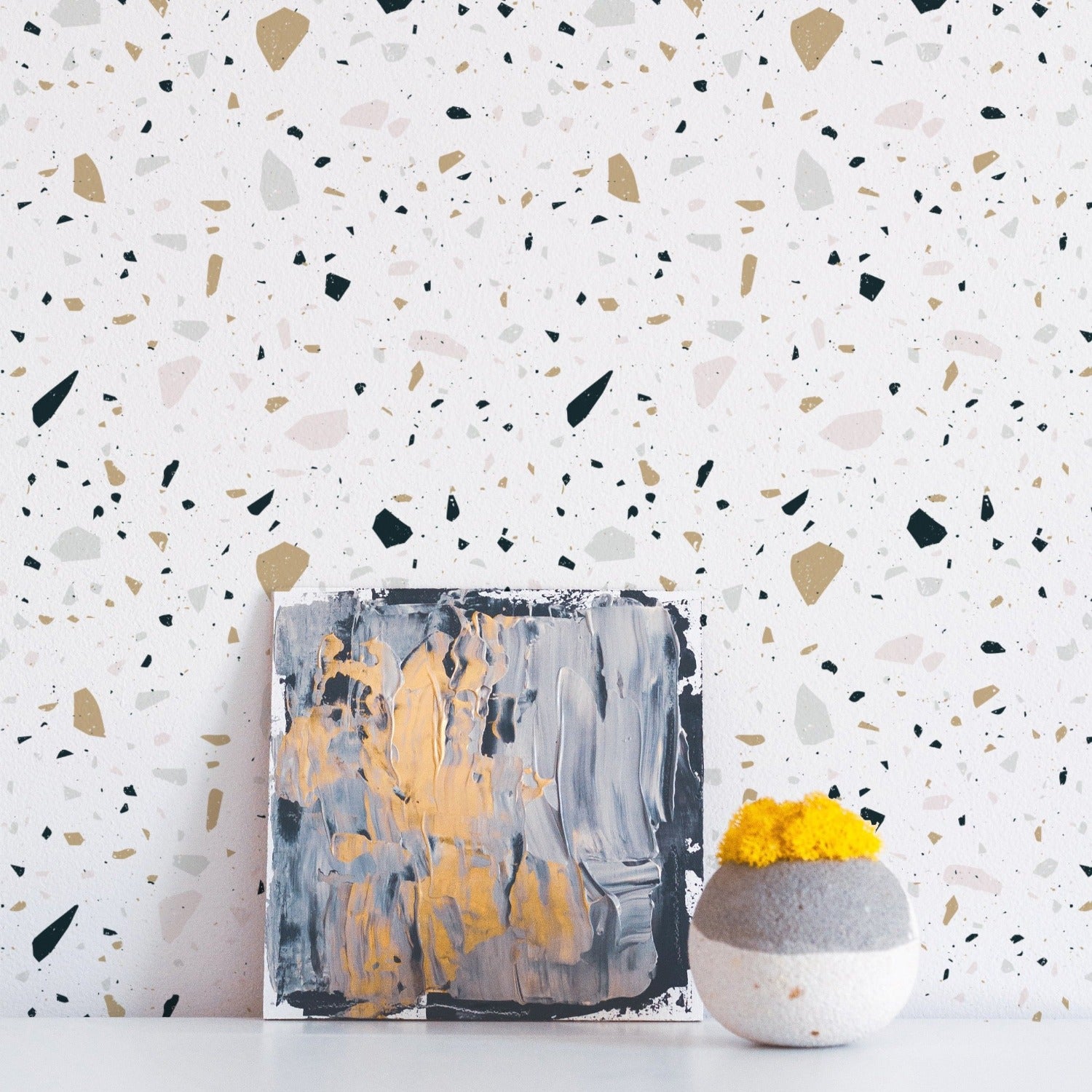 Stone Terrazzo Wallpaper in a stylish interior, complementing a modern painting and a textured vase with vibrant yellow flowers, highlighting the wallpaper's versatility and contemporary appeal.