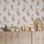 A children's playroom wall adorned with Cute Monkey Wallpaper, creating a lively and fun atmosphere. The wallpaper's beige and taupe monkey designs contrast beautifully against the wooden toy storage and colorful toys.