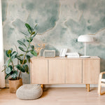 Stylish home office corner decorated with Shimmering Marble Wallpaper that exhibits a striking blue and green marble design with gold lines. The decor includes a white lamp, radio, and books on a modern wooden cabinet.