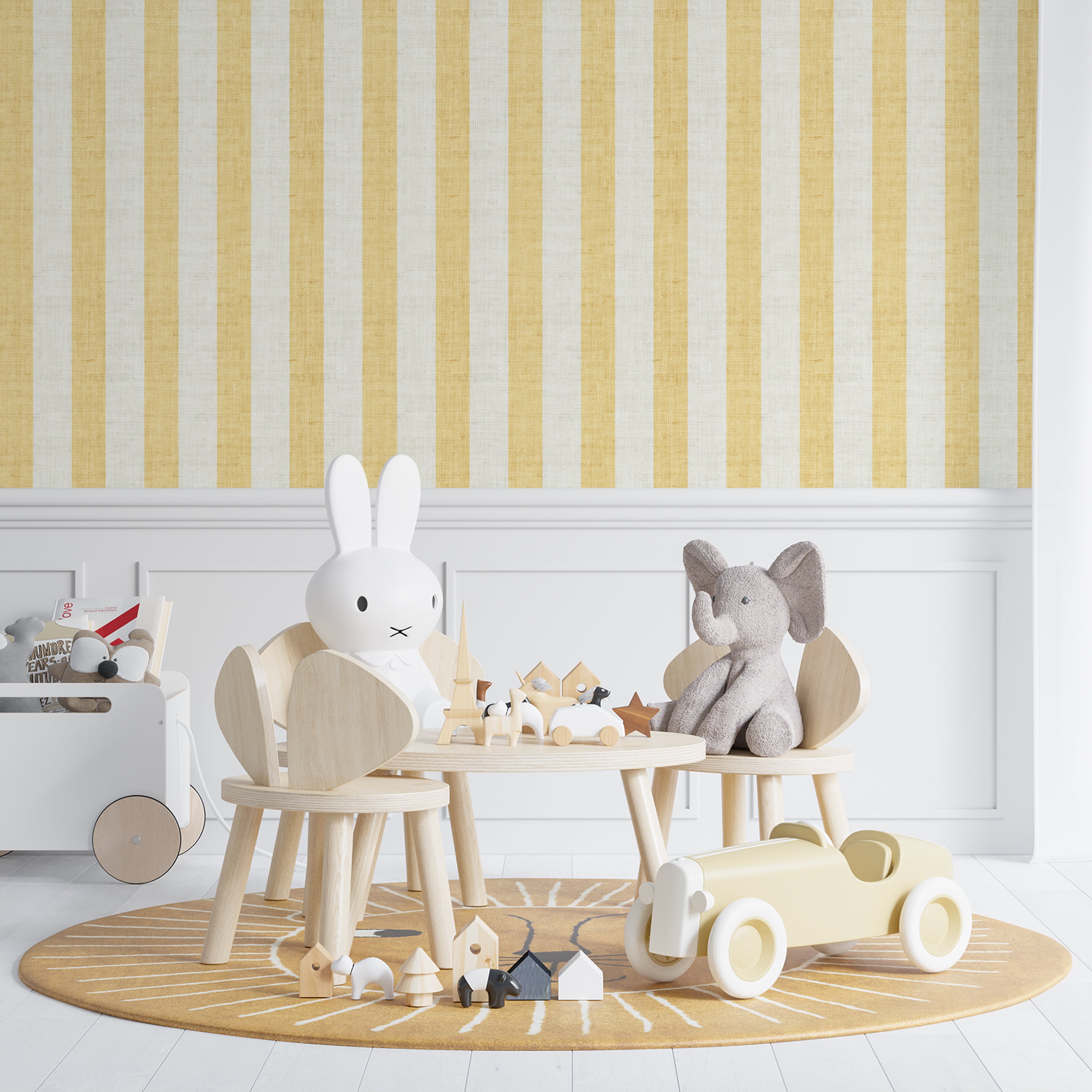 Child-friendly room setting displaying Ticking Fabrics 7 Wallpaper with vertical yellow and cream stripes. The scene includes a wooden children’s table with toys and stuffed animals, emphasizing the wallpaper’s suitability for lively and playful interiors