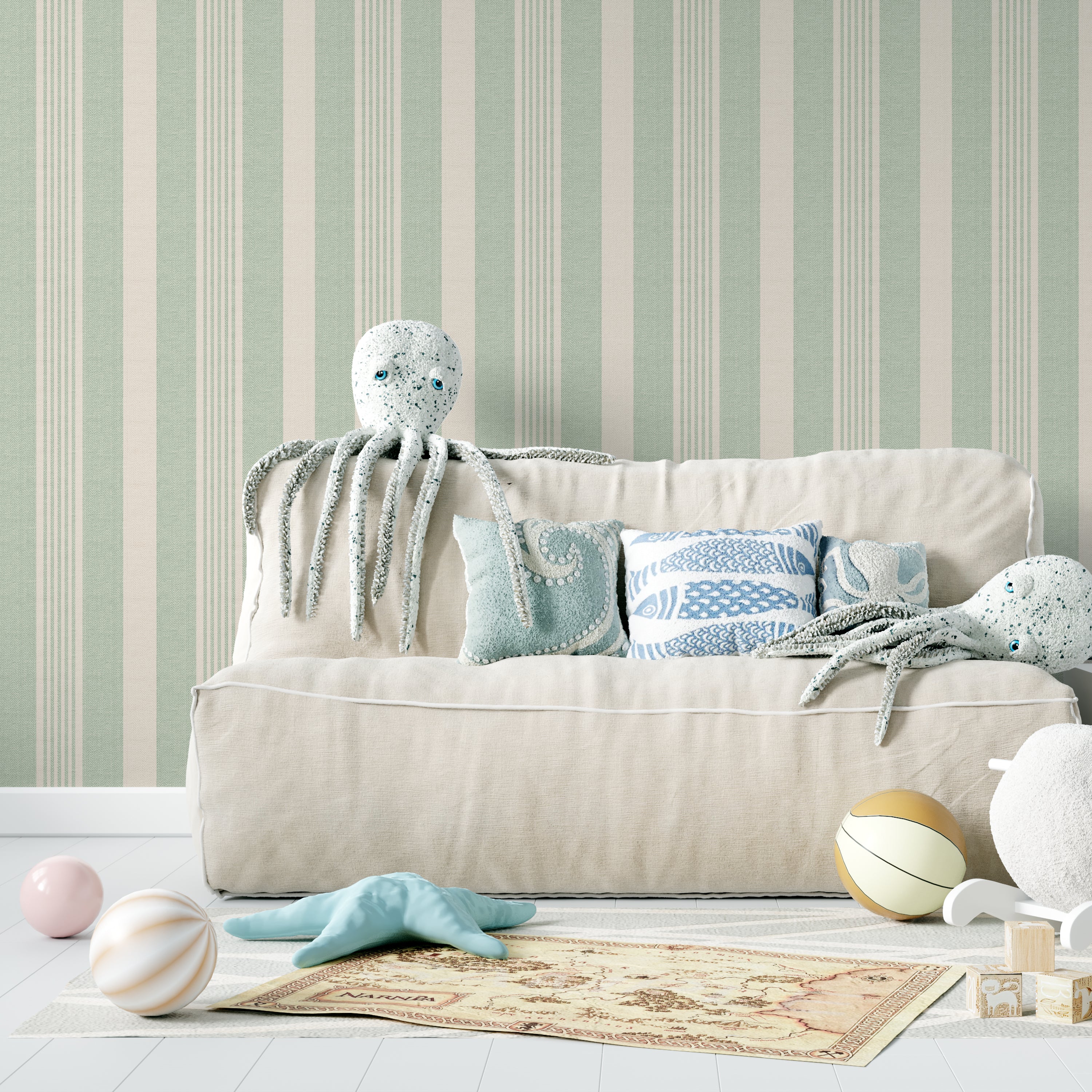 A whimsical children’s room setup showcasing Ticking Fabrics 12 Wallpaper with vertical stripes in sage green and cream. The scene includes plush sea creature toys on a sofa, enhancing the playful and inviting atmosphere of the room, perfect for a child's play area or bedroom