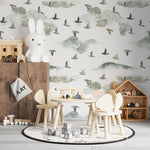 A child's playroom with the "Wild Pinery Wallpaper" adorning the walls, creating a whimsical backdrop for play and imagination. The wallpaper's subtle depiction of a forest with birds in various poses complements the room's wooden toys and furniture, enhancing the space with a sense of outdoor adventure.
