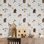 Decorative scene showing Forest Bear Wallpaper in a children's room setting. The wallpaper, filled with charming forest creatures such as bears, deer, and raccoons, complements a playfully arranged room with soft toys and children’s furniture, perfect for sparking imagination.