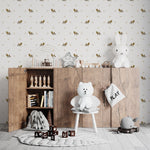 A playful and educational children's room setup showcasing Forest Leaf Wallpaper. The wallpaper's pattern of oak leaves and acorns adds a natural touch above wooden furniture filled with toys and educational materials, creating an inviting and stimulating environment for learning and play