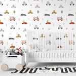 Nursery room decor highlighted by the Cute Cars Wallpaper 02 on the wall, showing playful scenes of cartoon cars driven by animals. The setting includes a white crib filled with plush toys, creating a cheerful and engaging atmosphere for children