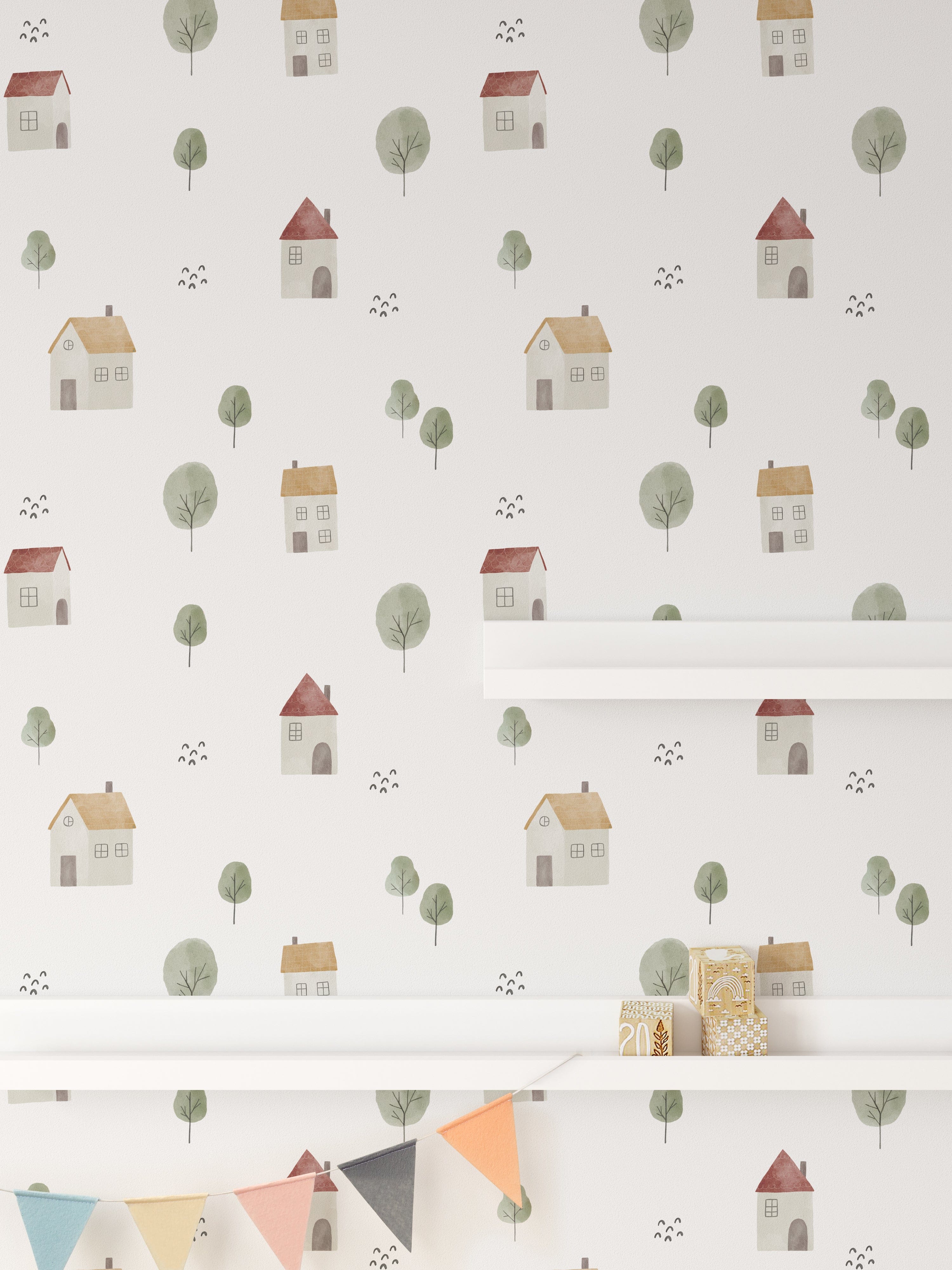 A section of a wall decorated with Farm Friend Wallpaper - Happy House, featuring charming houses and trees, along with a white shelf and colorful pennant banner, adding a cheerful touch to a child's room.