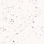 Close-up of the Ink Spatter Wallpaper, featuring a playful pattern of multi-colored paint splatters on a white background. The dots and specks in shades of blue, grey, and orange provide a vibrant and dynamic look, perfect for a lively interior setting.