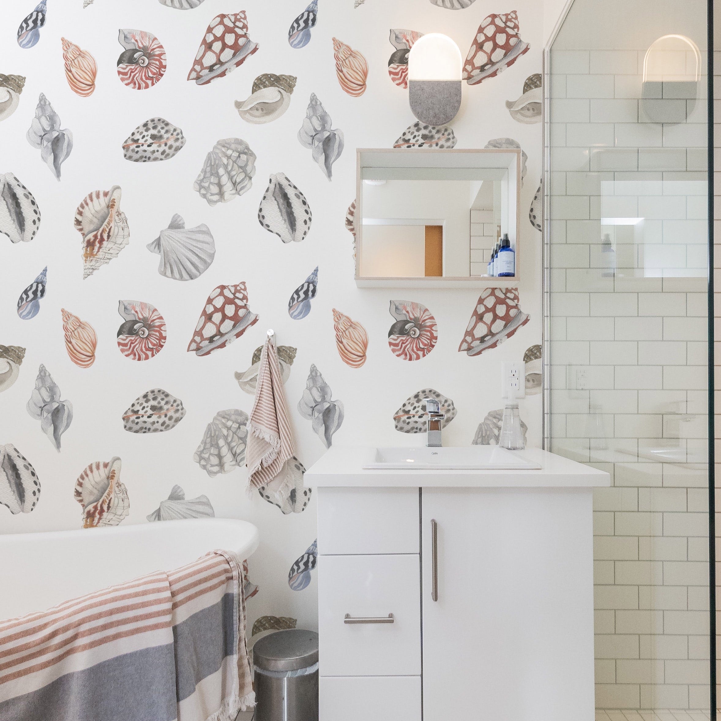 Modern bathroom decorated with watercolor seashell wallpaper and minimalist white vanity