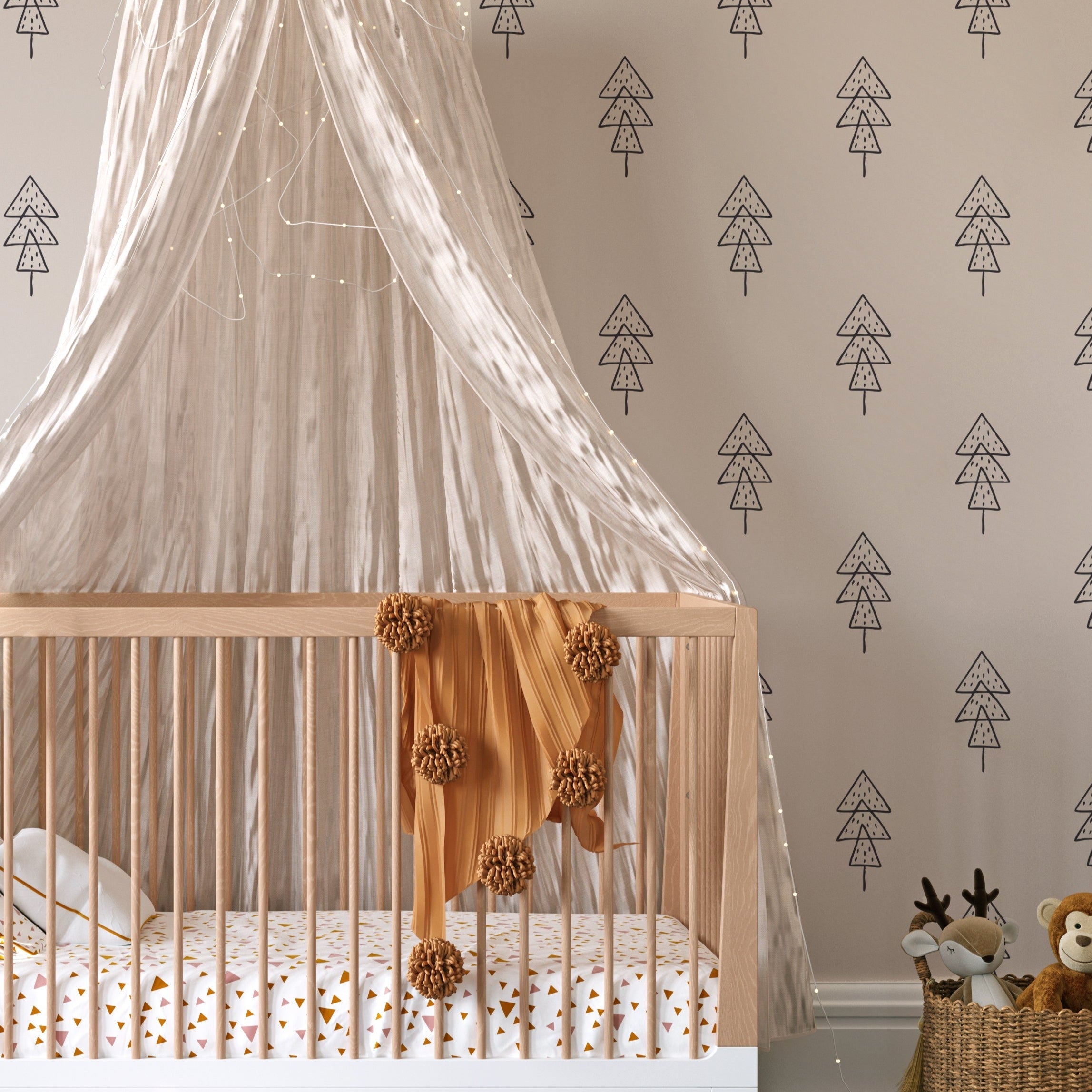 A cozy nursery room with one wall covered in Forest Animal Nursery Wallpaper. The wall features a repetitive pattern of stylized black pine trees on a soft grey backdrop, complementing the room's tranquil theme. A white crib with a sheer canopy and playful bedding enhances the nursery's soothing, woodland-inspired environment.